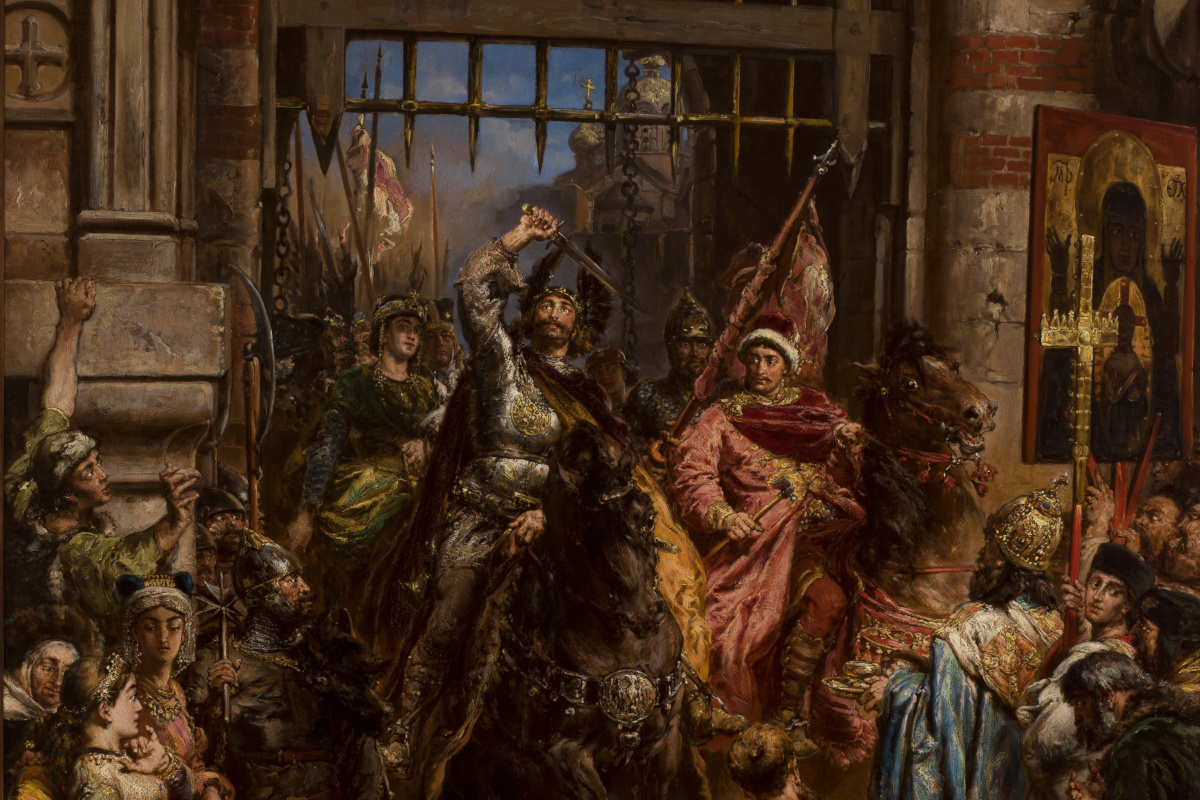 Ilustracja przedstawia historyczną scenę pod bramą. W centrum żołnierz na koniu unosi miecz, a obok niego stoi mężczyzna w czerwono-złotym stroju trzymający młot. Wokół grupa ludzi w ozdobnych ubraniach, część trzyma flagi. W tle widoczna ikona religijna oraz kolumny i architektoniczne detale bramy.