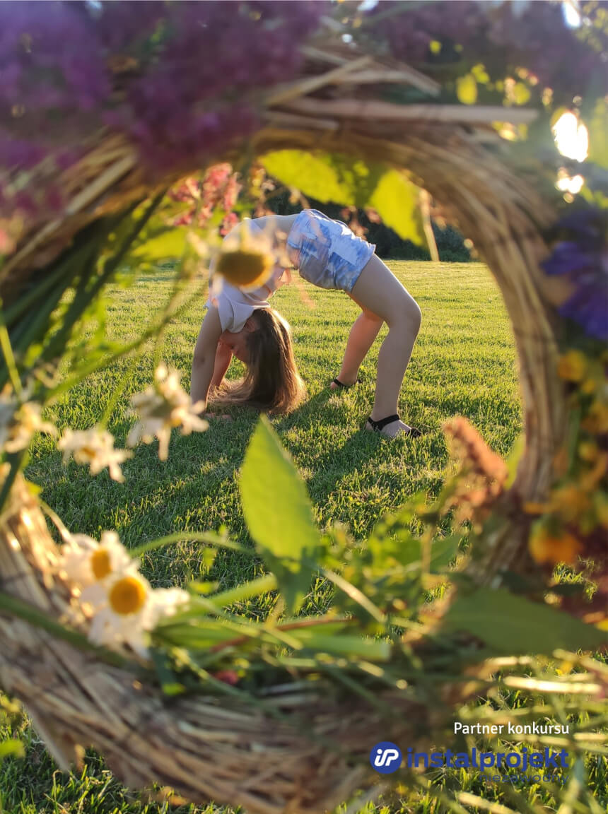 Dziewczynka robiąca mostek na trawie.