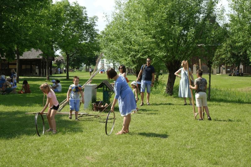 Dzieci i dorośli bawiący się na trawniku (źródło: lednicamuzeum.pl)
