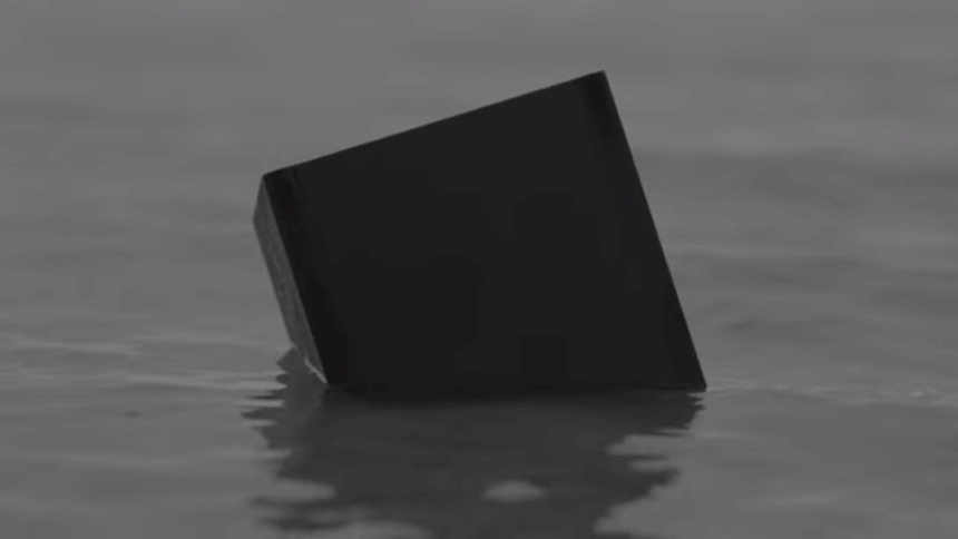 Czarna kostka (sześcian) dryfująca na wodzie