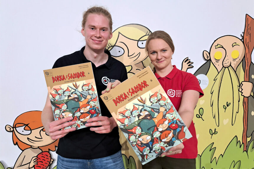 Dwoje młodych ludzi - chłopak i dziewczyna, prezentują najnowszy tom komiksu serii "Borka i Sambor"