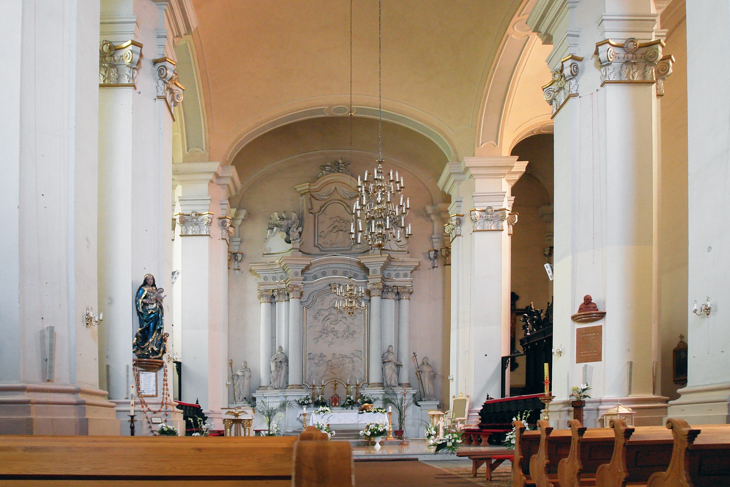 wnętrze kościoła. na pierwszym planie drewniany ławy. Po bokach jasne, wysokie kolumny. w oddali - ołtarz